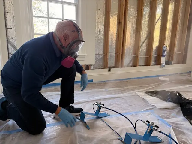 A restoration technician setting drying equipment in an Huntsville home stripped to the studs